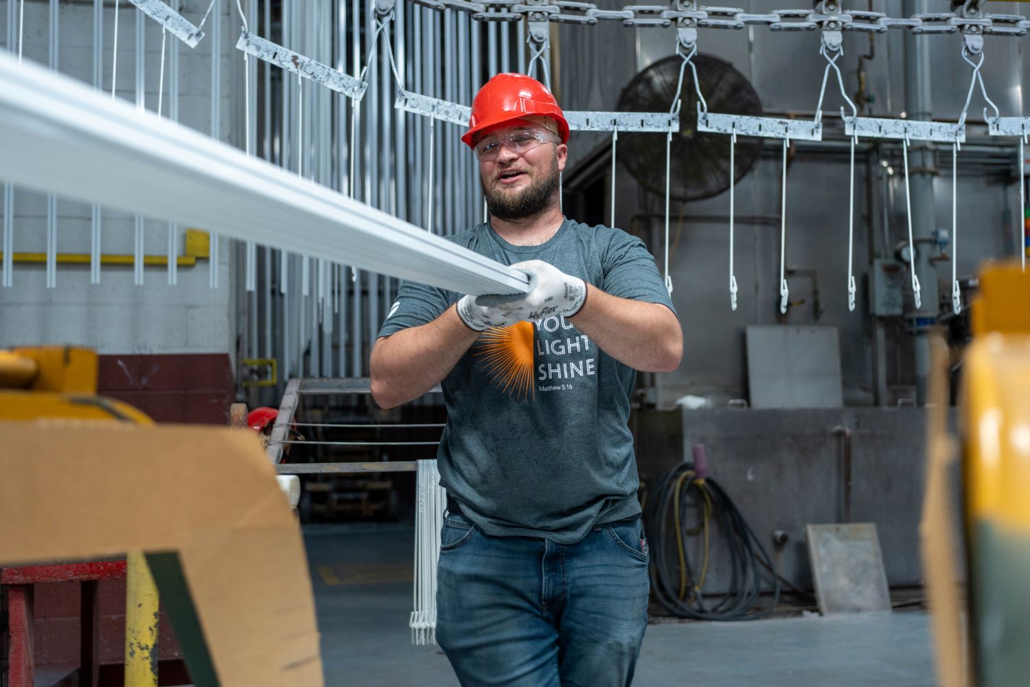 factory employee holding one end of extrusion
