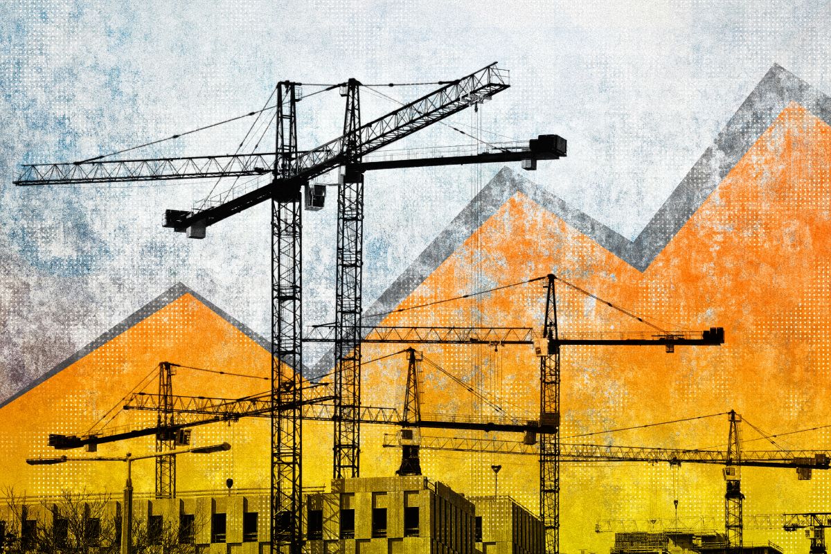 construction cranes against rising and falling graph line